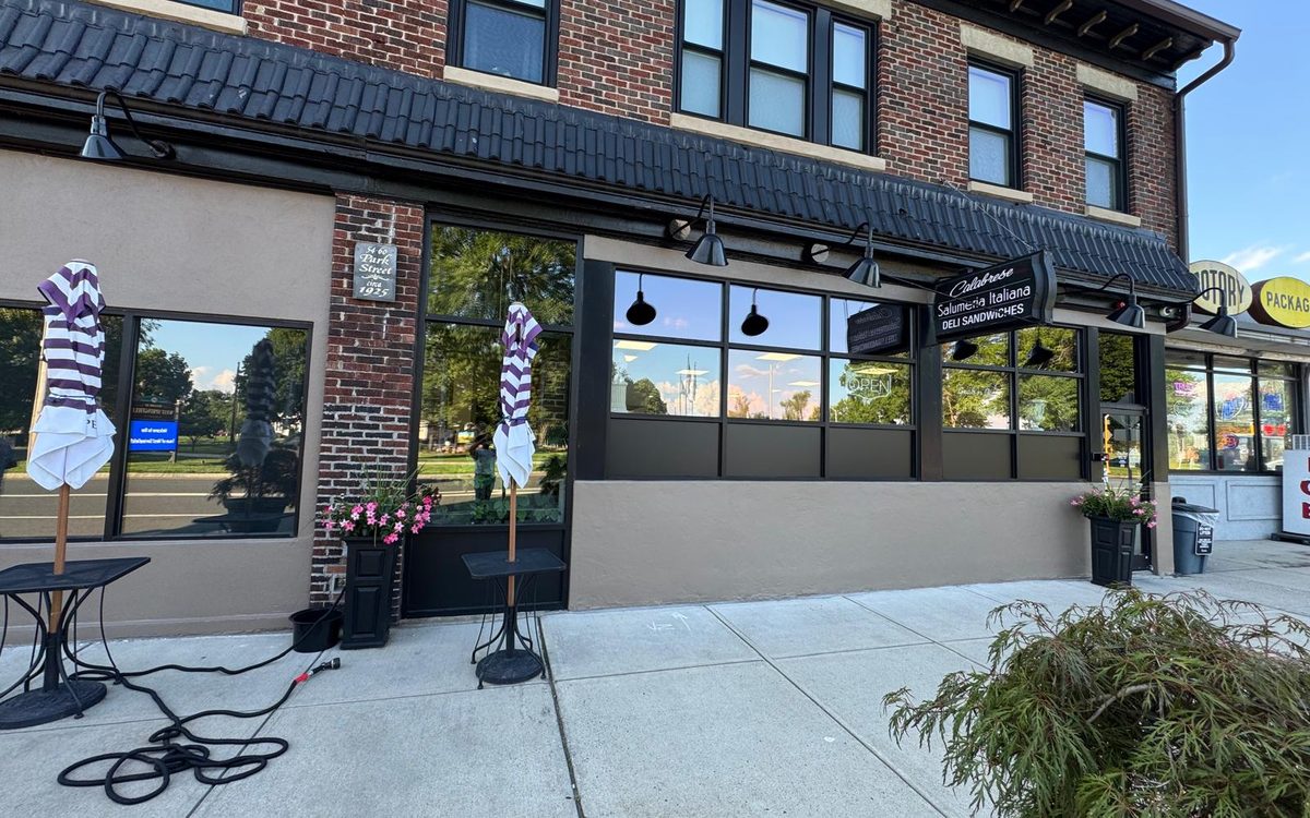 Brick storefront with freshly painted stucco base and dark trim