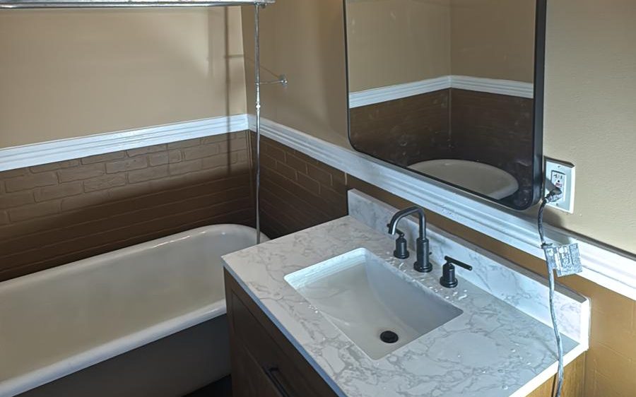 Repainted bathroom with warm two-tone walls, white chair rail and crown molding