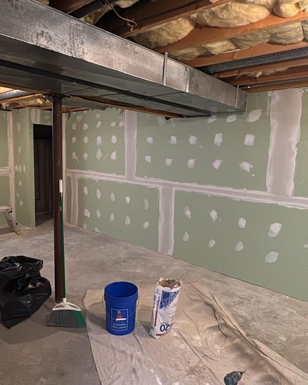 Basement drywall with taped and mudded seams and screw spots