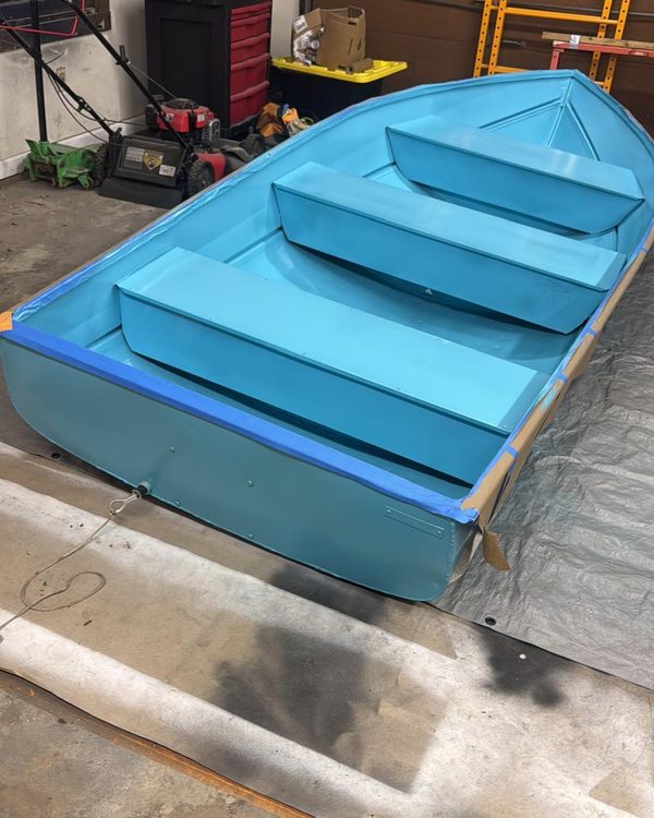 Aluminum boat after refinishing in a bright aqua coat