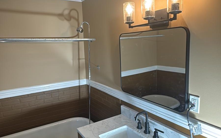 Repainted bathroom with warm two-tone walls, white chair rail and crown molding
