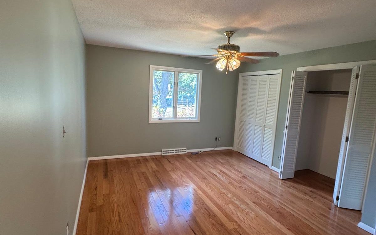 Finished bedroom with sage green walls and white trim