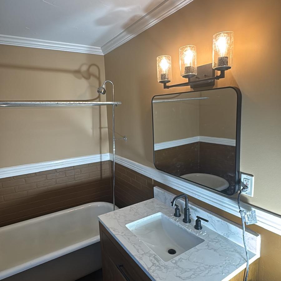 Repainted bathroom with warm two-tone walls, white chair rail and crown molding