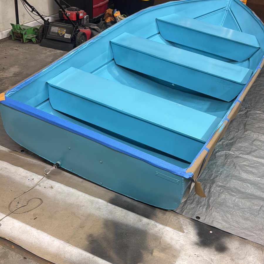 Aluminum boat after refinishing in a bright aqua coat