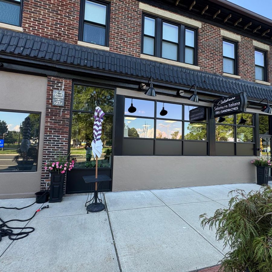 Brick storefront with freshly painted stucco base and dark trim