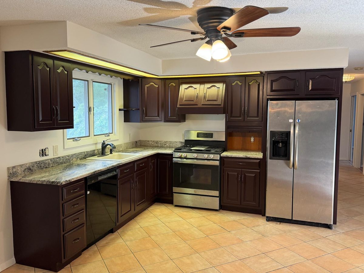Kitchen with cabinets painted in a deep espresso finish and stainless appliances