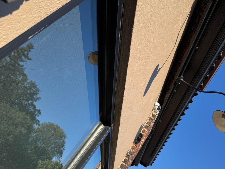 Close-up of freshly painted stucco and window trim on a storefront