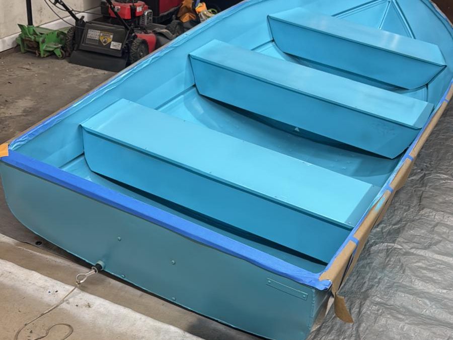 Aluminum boat after refinishing in a bright aqua coat