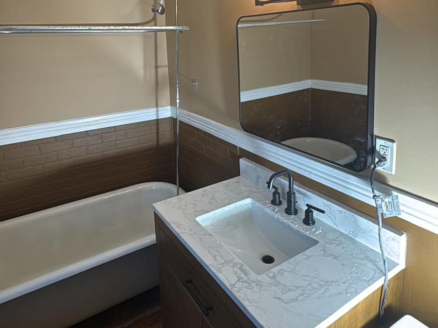 Repainted bathroom with warm two-tone walls, white chair rail and crown molding