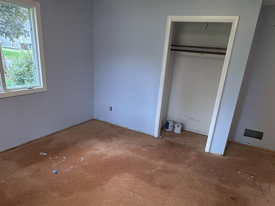 Bedroom freshly painted in soft blue with white trim and closet