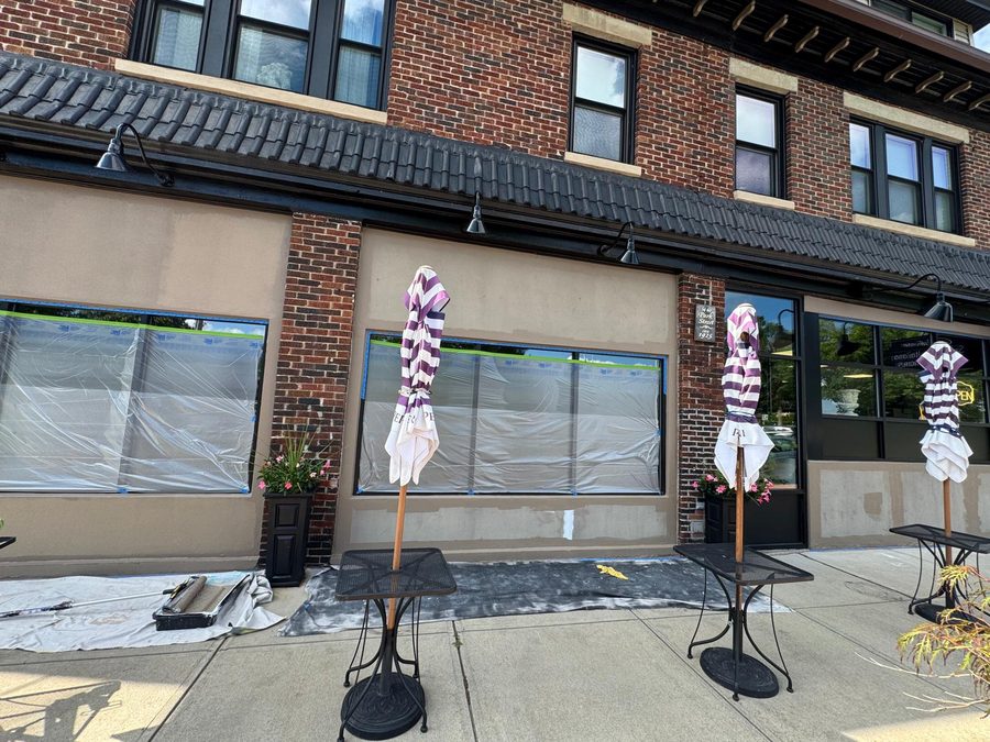 Storefront masked with plastic and tape during exterior repaint