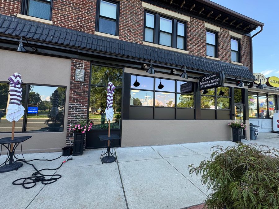 Brick storefront with freshly painted stucco base and dark trim