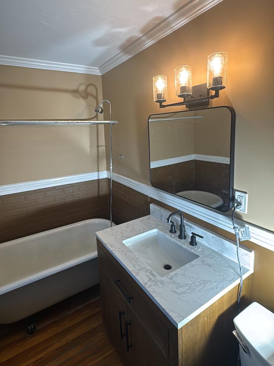 Repainted bathroom with warm two-tone walls, white chair rail and crown molding