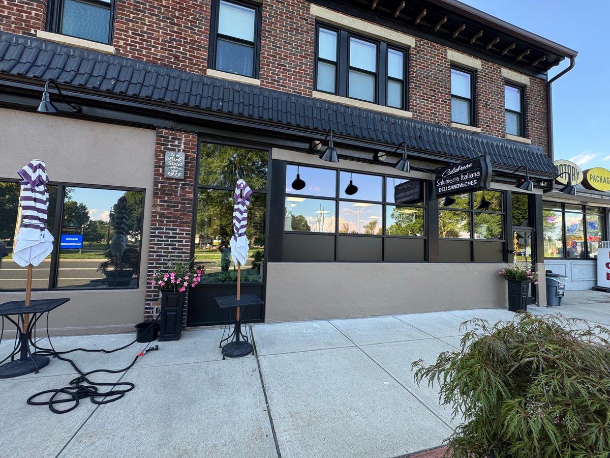 Brick storefront with freshly painted stucco base and dark trim