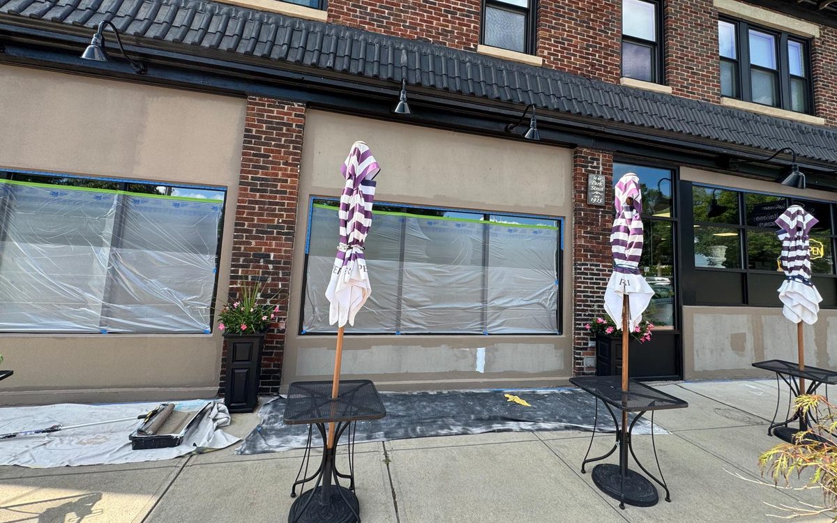 Storefront masked with plastic and tape during exterior repaint