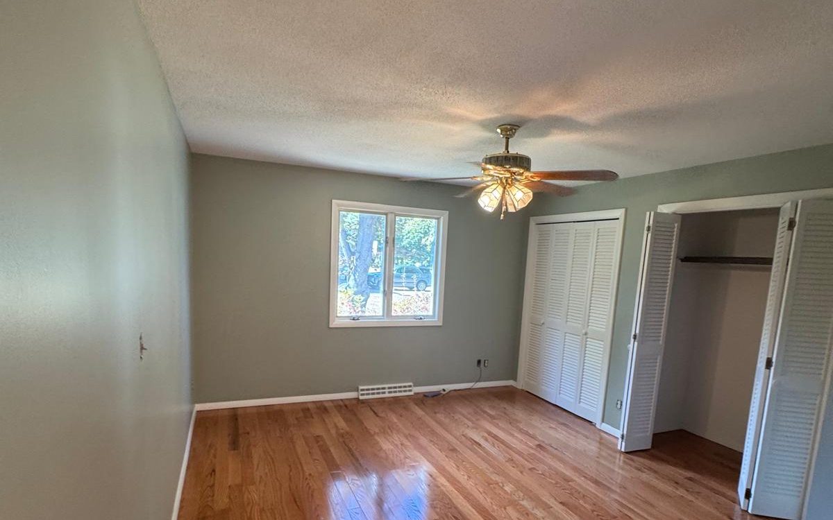 Finished bedroom with sage green walls and white trim