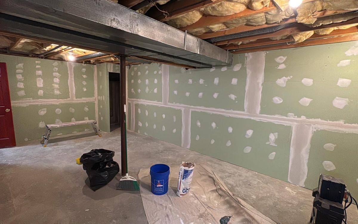 Basement drywall with taped and mudded seams and screw spots