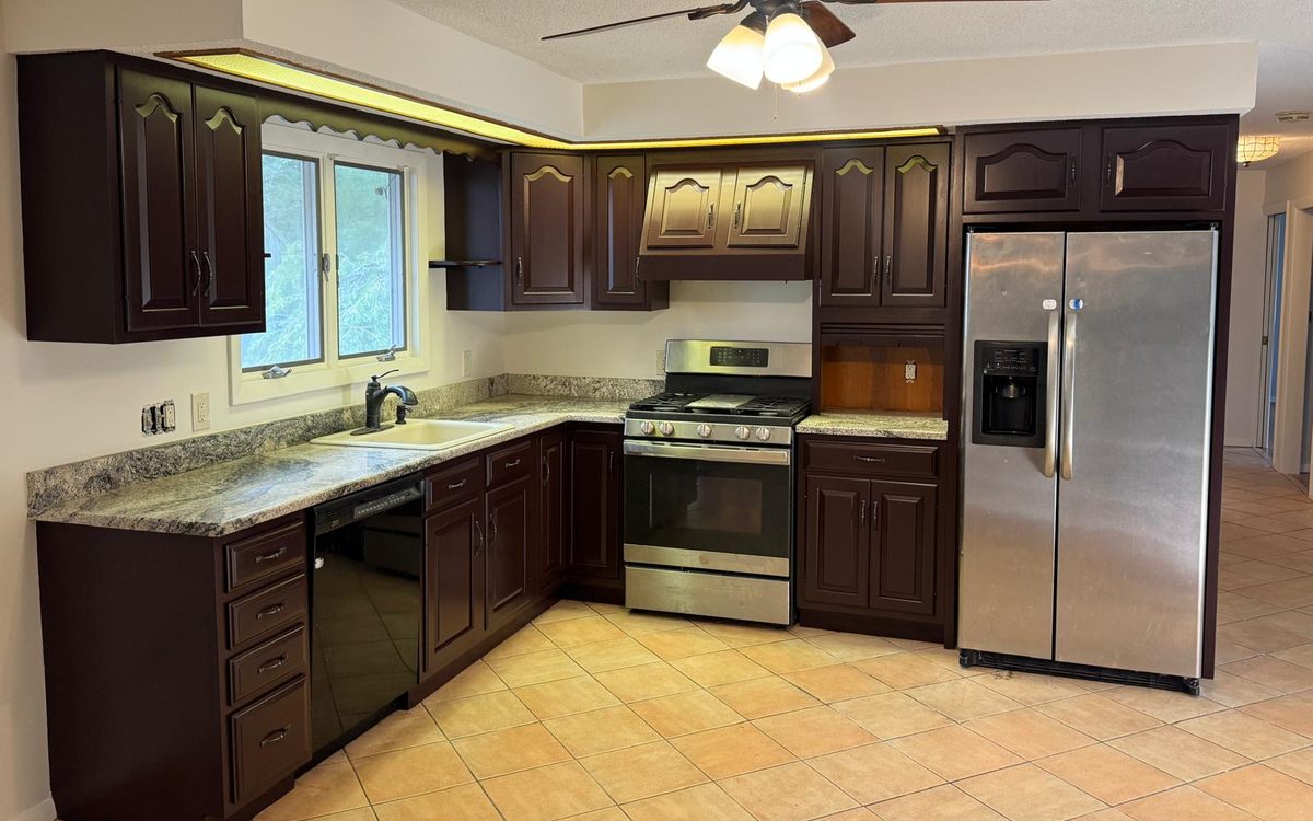 Kitchen with cabinets painted in a deep espresso finish and stainless appliances